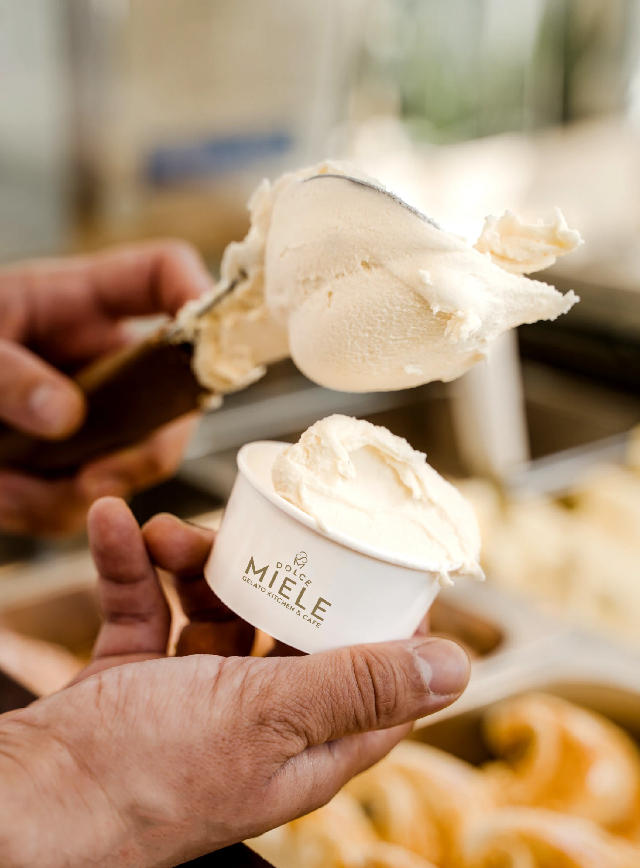 Fresh gelato being served into a Dolce Miele tub